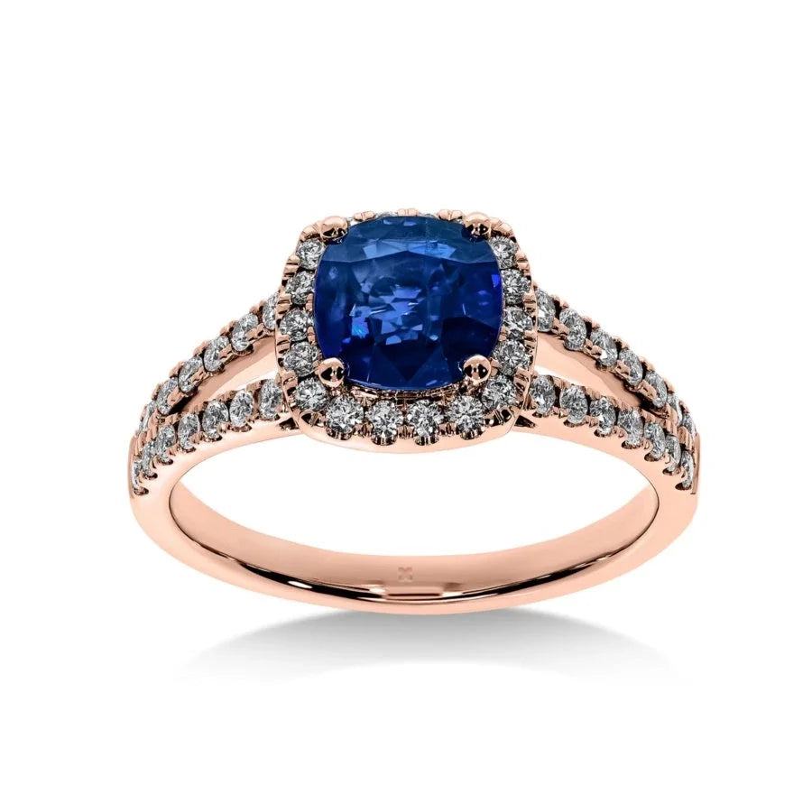 Gros plan du saphir bleu sur la bague Saphir Impérial en or rose, mettant en valeur la taille coussin et le pavage de diamants."