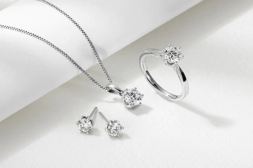 une bague de fiançailles , un pendentif en or et diamant et des boucles d'oreilles en diamants