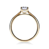 Gros plan du diamant émeraude sur la bague Trésor en or jaune, mettant en valeur la brillance certifiée GIA.